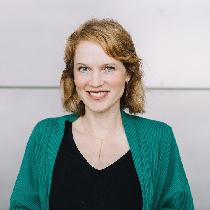 Foto der Person hinter der Illustration, lächelnd in einer grünen Strickjacke
